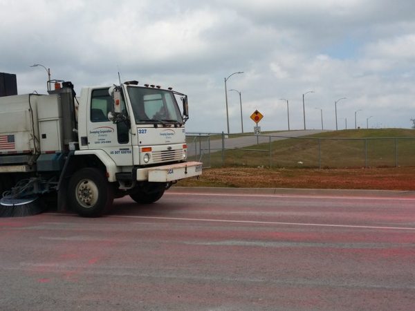 Sweeper truck cleaning red power off the road