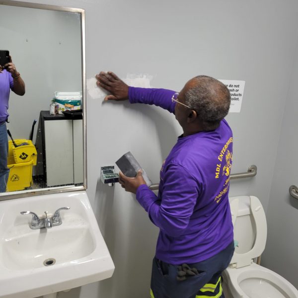 Man patching a bathroom wall