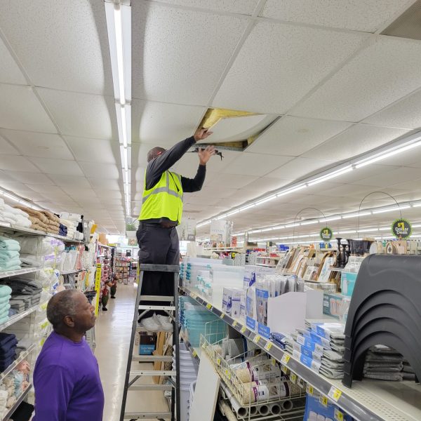 Man on a ladder removing ceiling tile