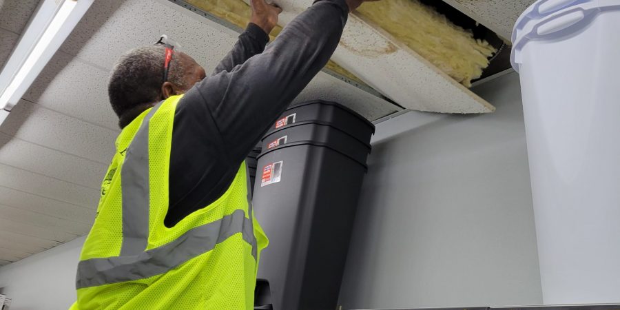 Man removing a stores ceiling tile